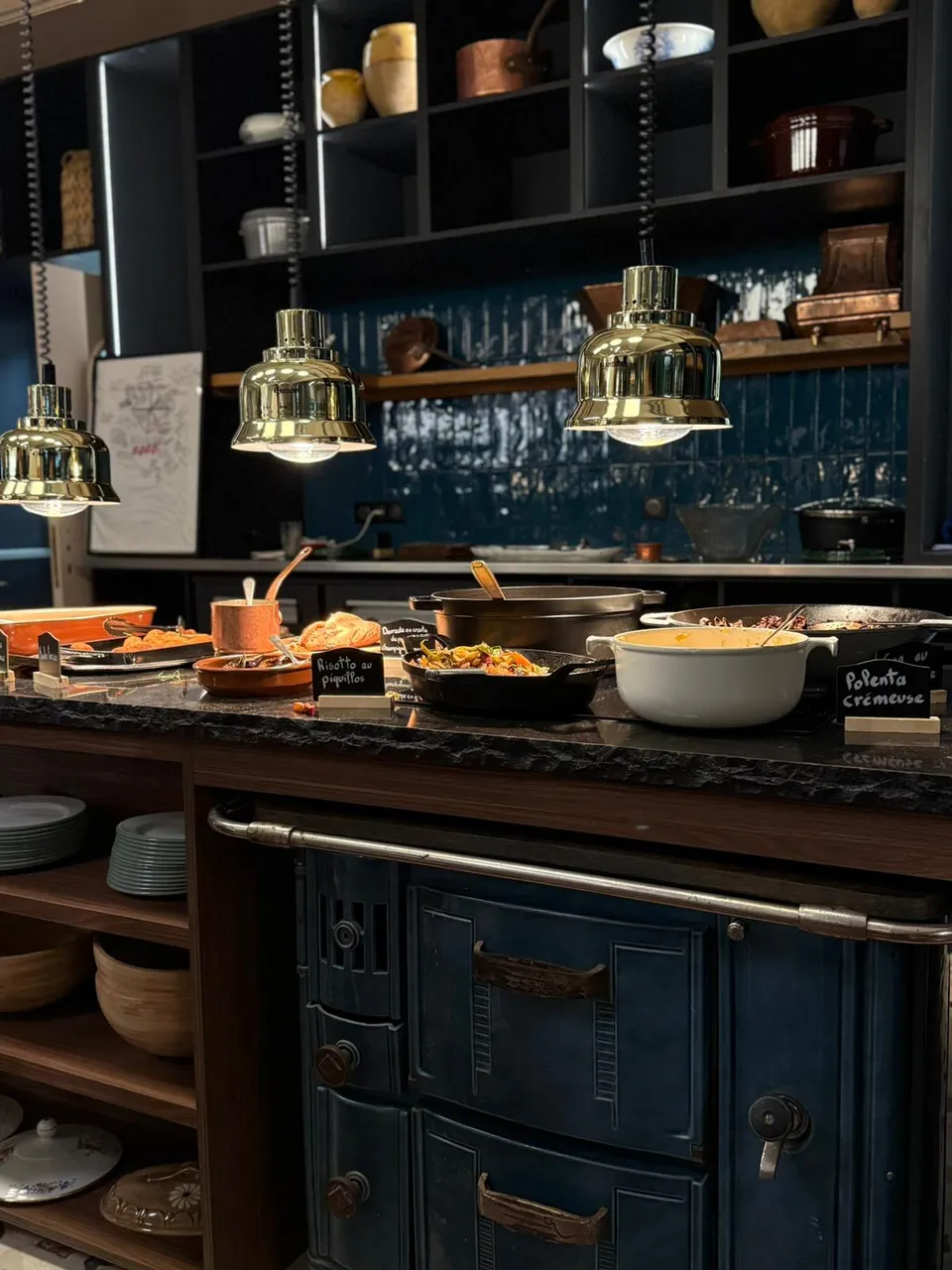Les plats chauds du buffet sous les suspensions dorées